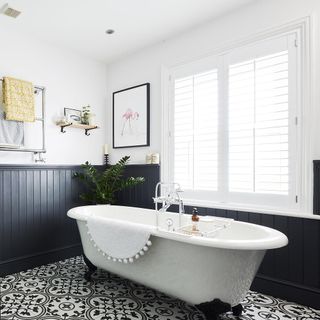 Bathroom with freestanding tub and dark blue wooden paneling