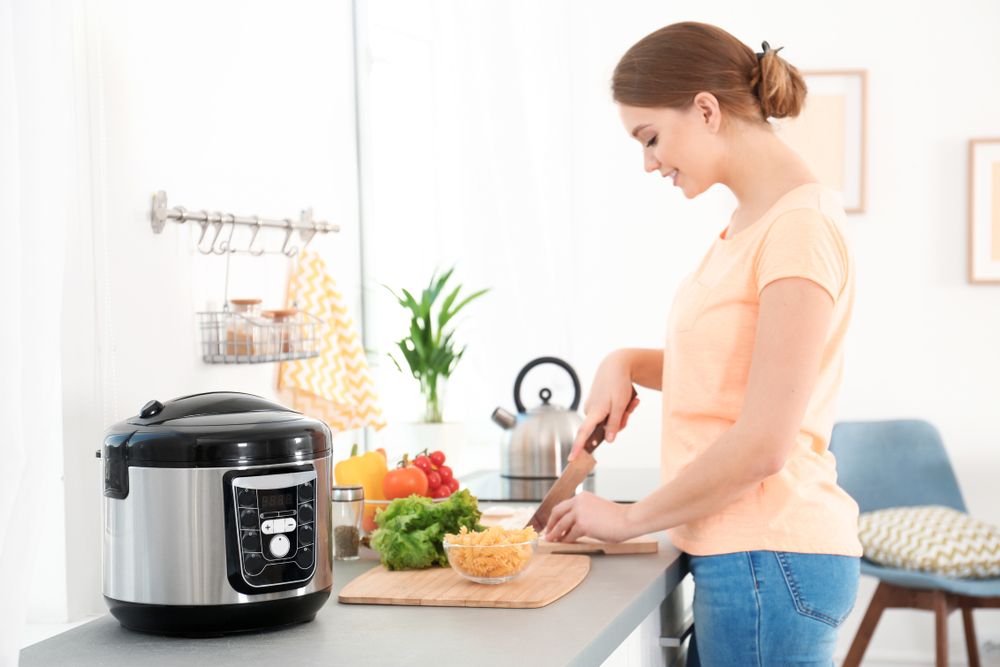 woman cooking in kitchen with pressure cooker