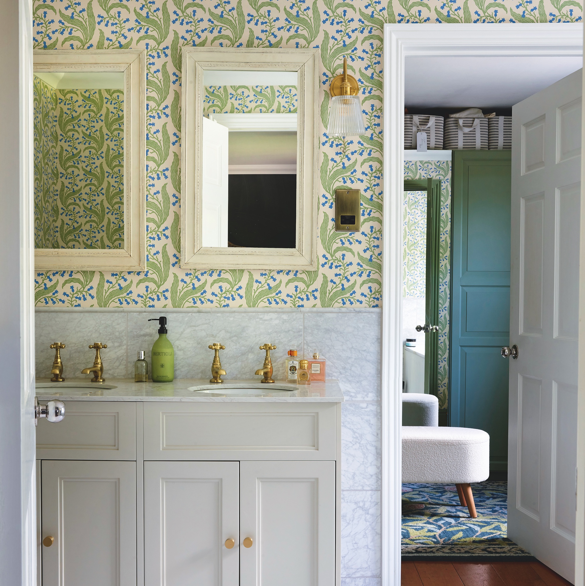 ensuite bathroom with green leaf wallpaper and pale grey vanity unit with twin inset basins