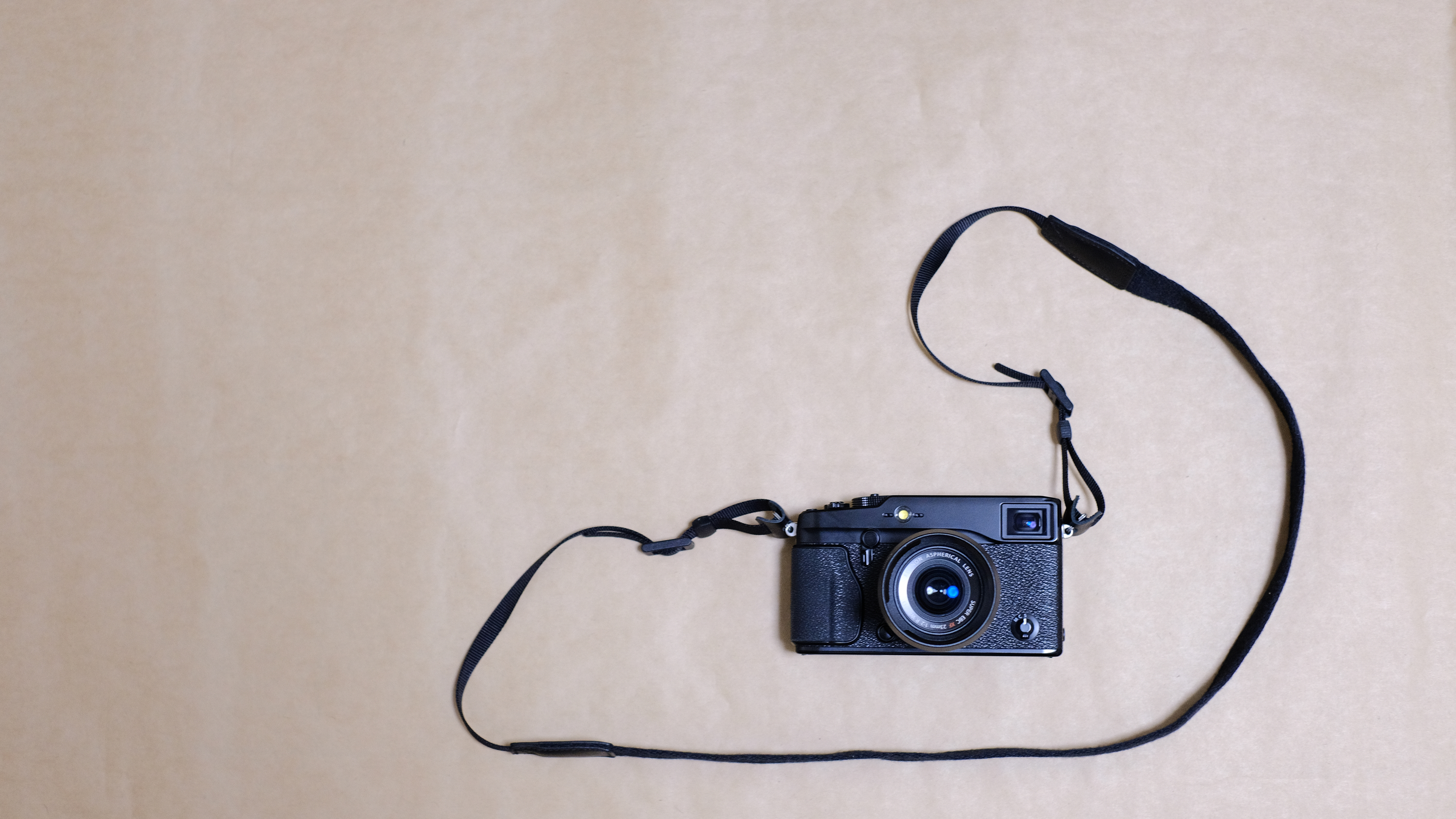 The Fujifilm XF 35mm f/1.4 R on the X-Pro 1 on a tan background
