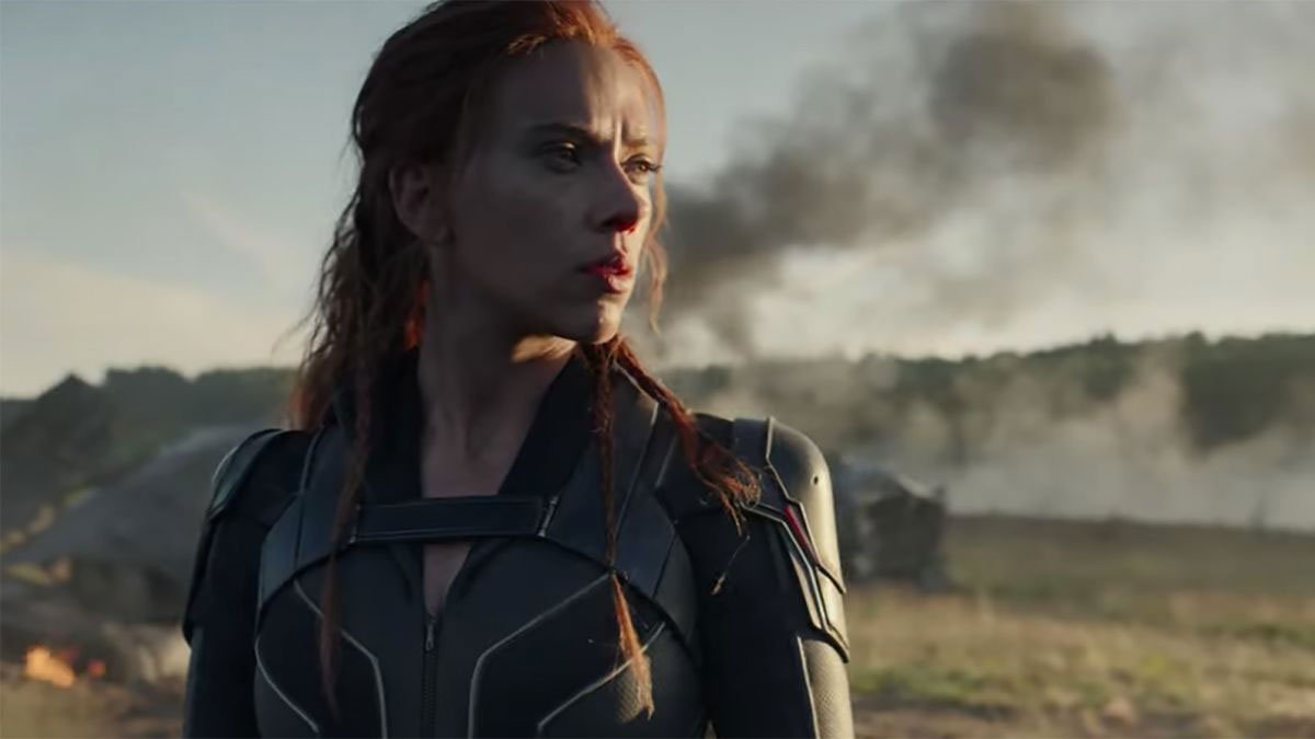 Black Widow looking intense outside as a fire burns behind her.