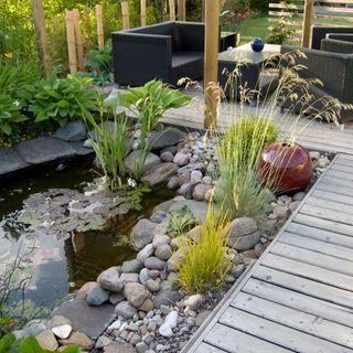garden area with pond and plants with stones