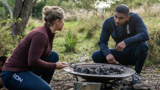 DeShawn and Evie kneeling next to fire pit in NCIS: Sydney