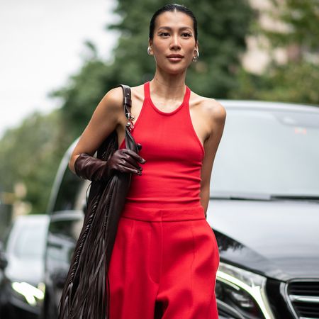 fashion week attendee wearing red tank top, red pants, brown glove