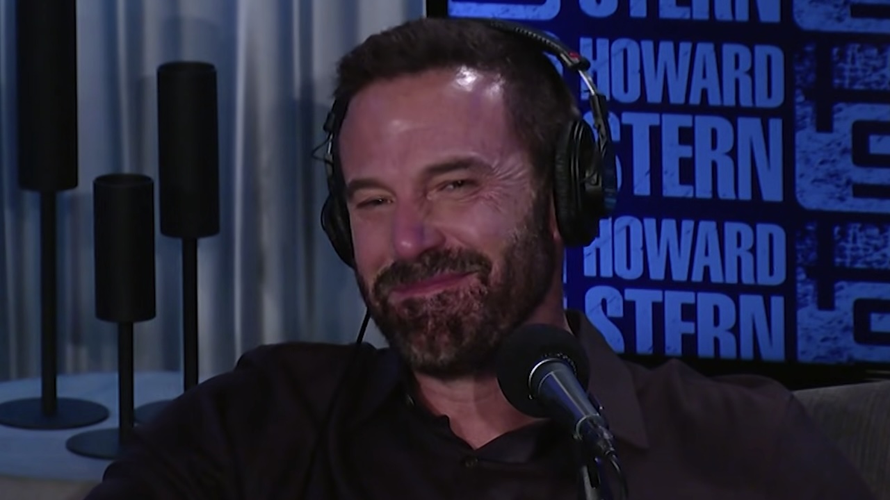 Ben Affleck trying to hold back a big smile while on The Howard Stern Show with Matt Damon