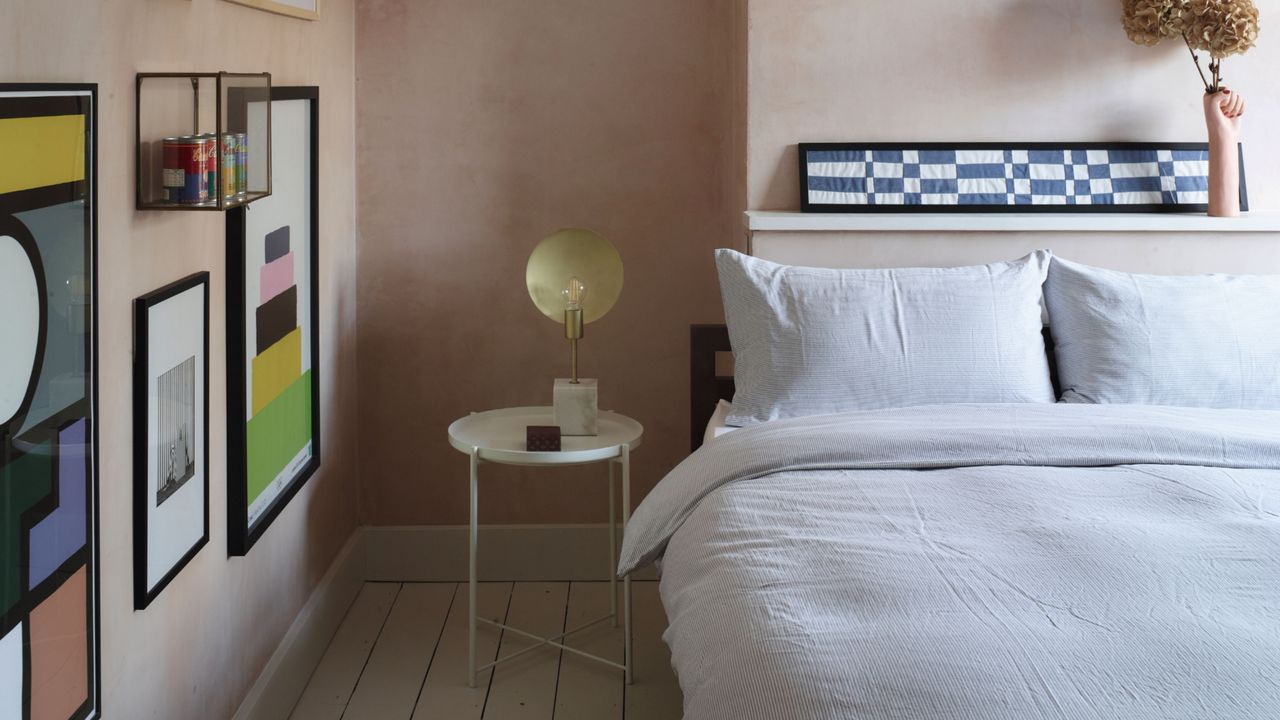 Bedroom with limewashed walls and bed with white bedding and gallery wall