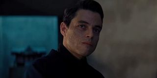 No Time To Die Rami Malek sternly looks at James Bond