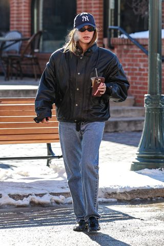 Hailey Bieber wears a bomber jacket with jeans and loafers in Aspen