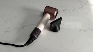 Dyson Supersonic Travel hair dryer alongside the smoothing nozzle attachment
