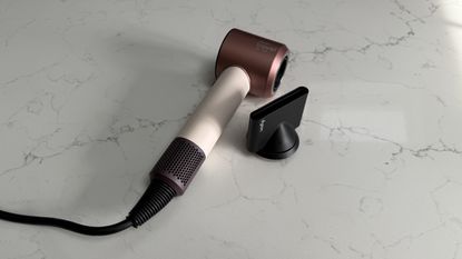 Dyson Supersonic Travel hair dryer alongside the smoothing nozzle attachment