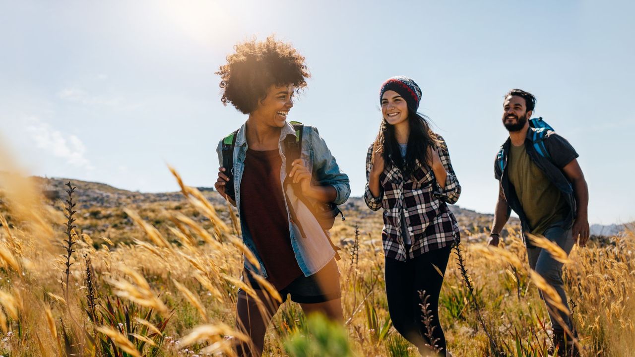 A group of three friends hiking together in the country