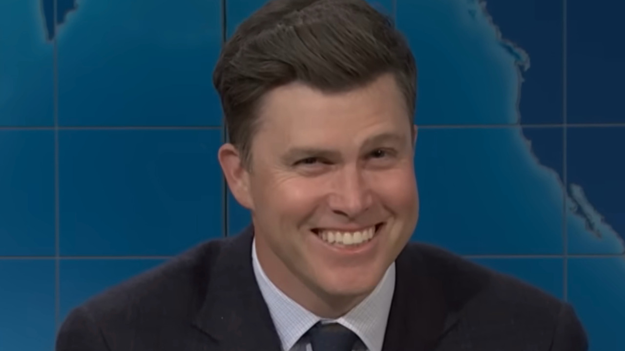 Colin Jost laughing nervously as he finds out he's about to have his head shaved.