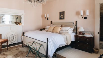 calming bedroom with pale pink walls, dark wooden furniture and white bedding