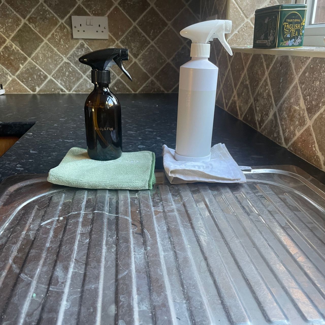 Purdy &amp; Figg and Smol cleaning bottles in front of a dirty draining board