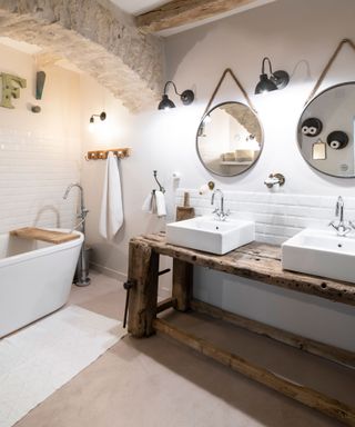 bathroom in a country house with double basins on an old wooden workbench and stone arch