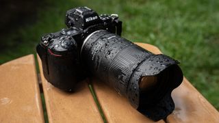 A lifestyle photo of the Tamron 18-300mm f/3.5-6.3 Di III-A VC VXD mounted on a Nikon camera in the rain