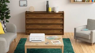 A Canon all-in-one printer sat on a table in a relaxed looking living room. 