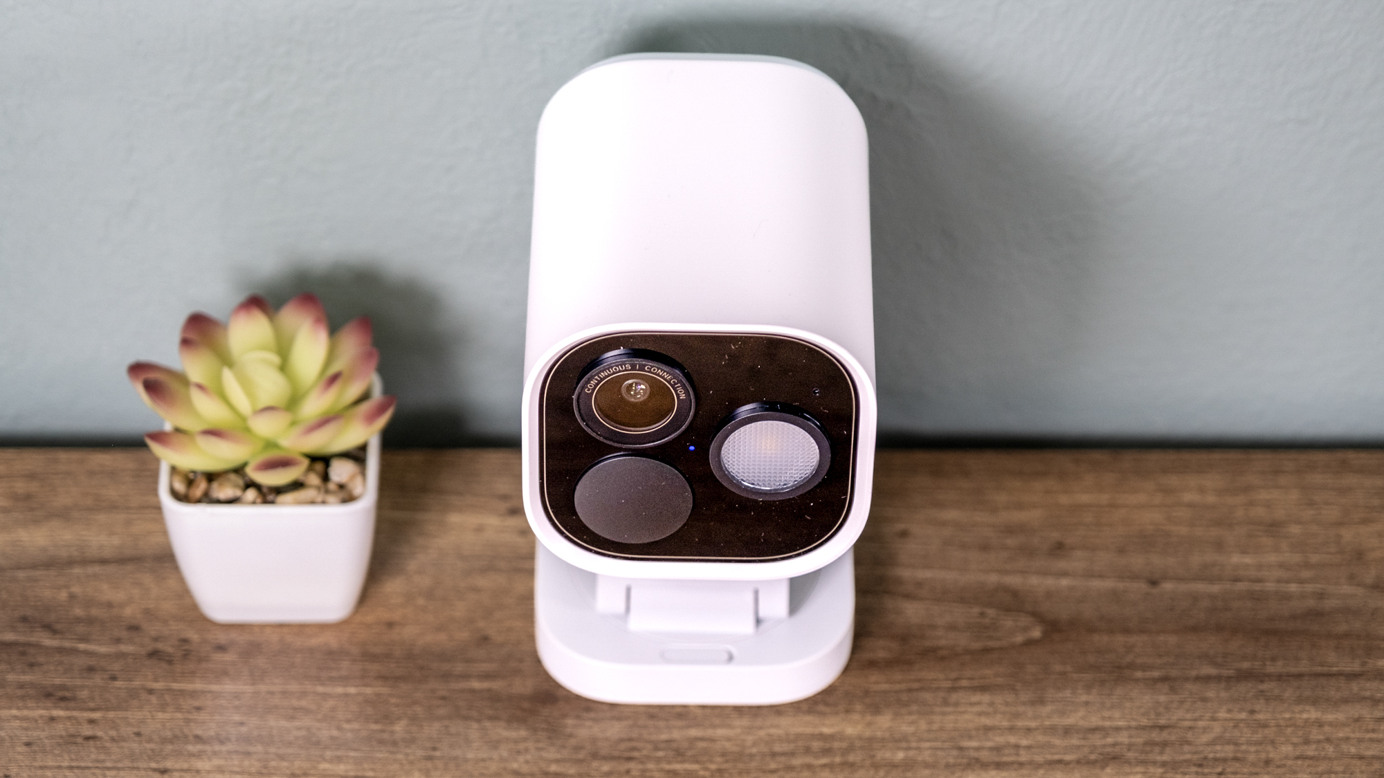 Aqara Camera Hub G5 Pro on a shelf with a small cactus.