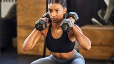 A woman doing dumbbell squats