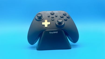 EasySMX D05 black gaming controller from the front on a charging stand on a blue background