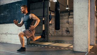Man performs TRX Bulgarian split squat in a gym