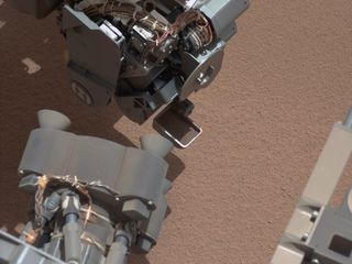 This image from the right Mast Camera (Mastcam) of NASA's Mars rover Curiosity shows a scoop full of sand and dust lifted by the rover's first use of the scoop on its robotic arm. In the foreground, near the bottom of the image, a bright object is visible on the ground. The object might be a piece of rover hardware. This image was taken during the mission's 61st Martian day, or sol (Oct. 7, 2012).