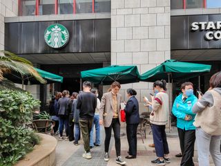 Customers with their own cups line up for free coffee at a Starbucks store on the 52nd Earth Day on April 22, 2021 in Shanghai, China.