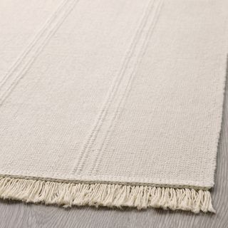 A beige flatwoven cotton rug