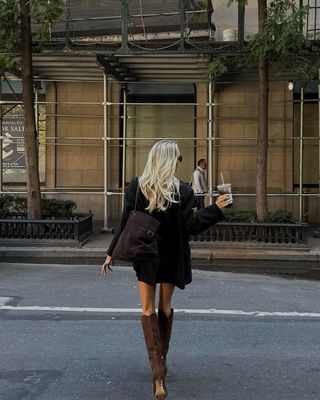 Woman wearing blazer minidress with tall suede brown boots.