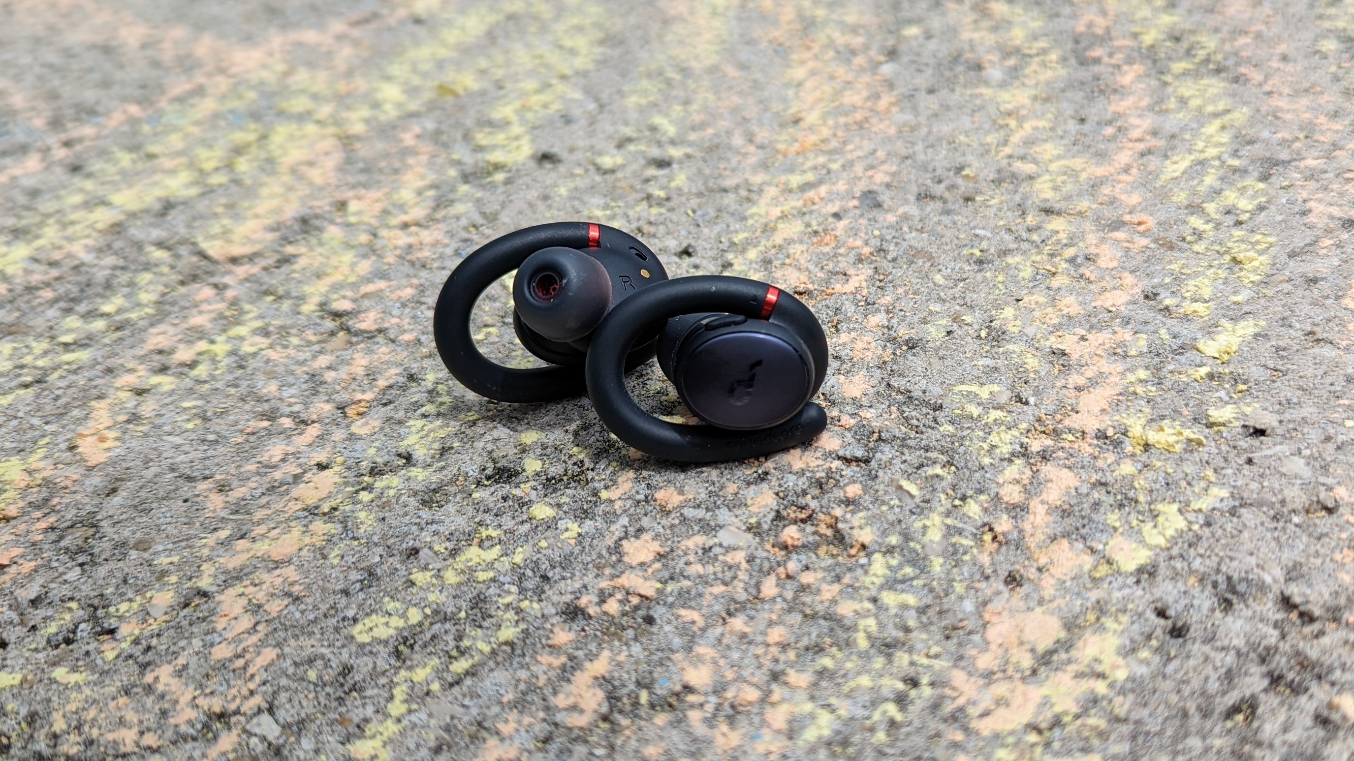 The Anker Soundcore Sport X10 wireless earbuds on the concrete