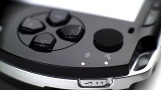 A press photo of a PlayStation Portable, focusing on the d-pad and analog stick