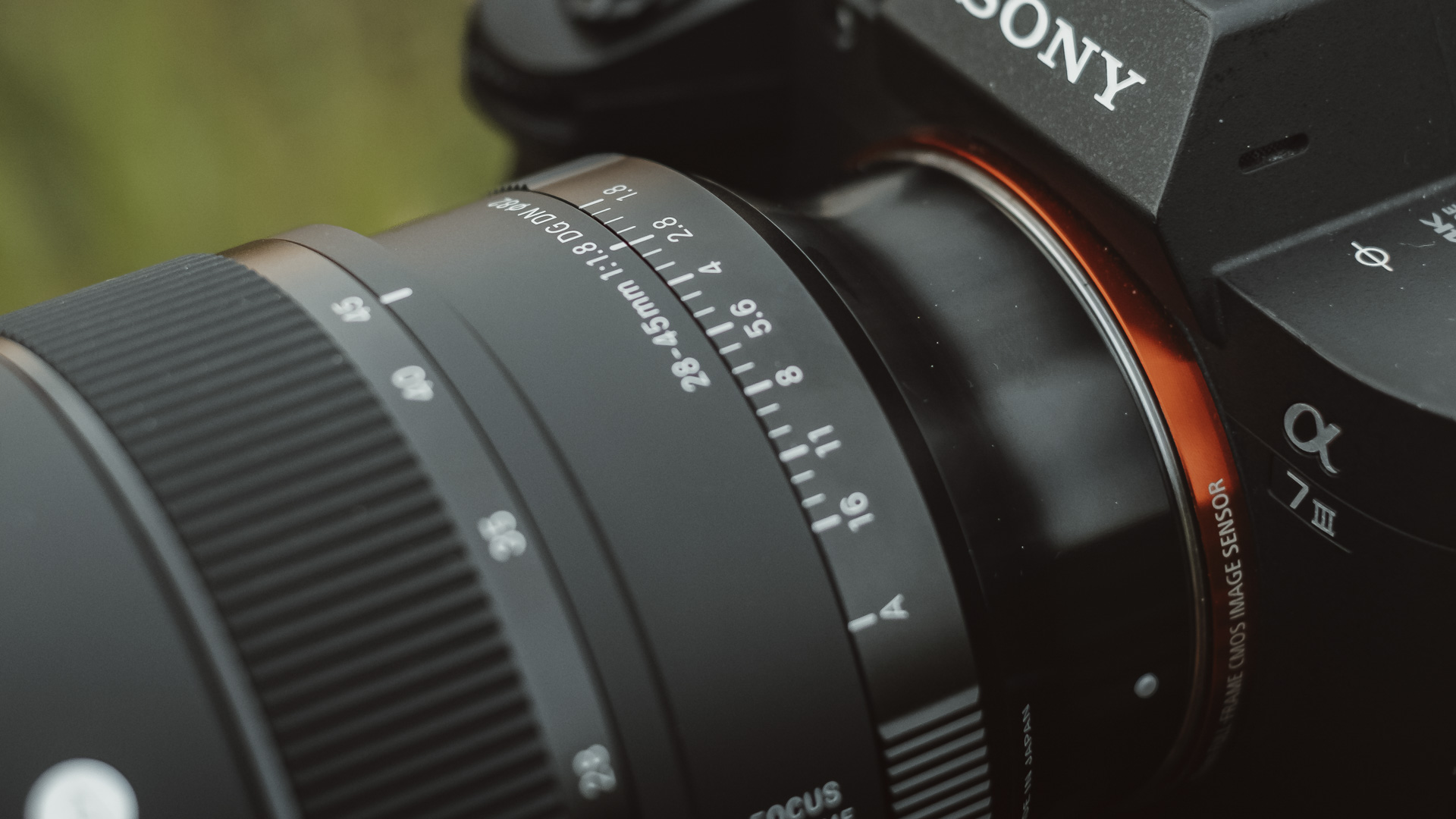Sigma 28-45mm F1.8 lens mounted on a Sony camera being held by a photographer