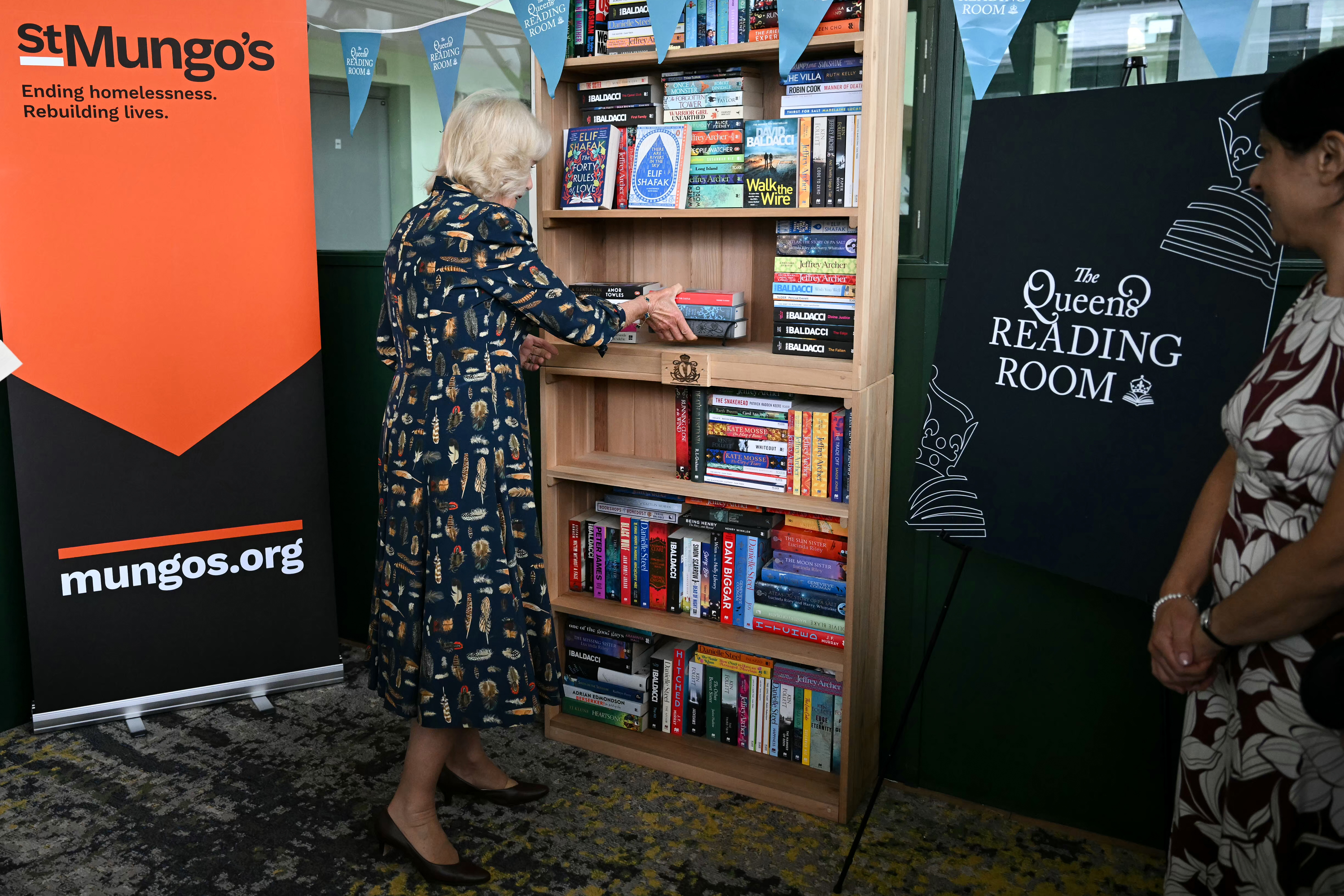 LONDON, ENGLAND - JUNE 10: Queen Camilla places books on shelves to highlight the activities offered by The Queen&amp;amp;apos;s Reading Room, during a visit to one of St Mungo&amp;amp;apos;s homelessness accommodation sites in south London, on June 10, 2026 in London, England. The Queen met with residents and staff who are connected to a shared reading programme enabled by The Queen&amp;amp;apos;s Reading Room. St Mungo&amp;amp;apos;s homelessness charity, founded in 1969, has for the past 56 years been supporting people as they rebuild their lives at Olympia Exhibition Centre. (Photo by Justin Tallis - WPA Pool/Getty Images)