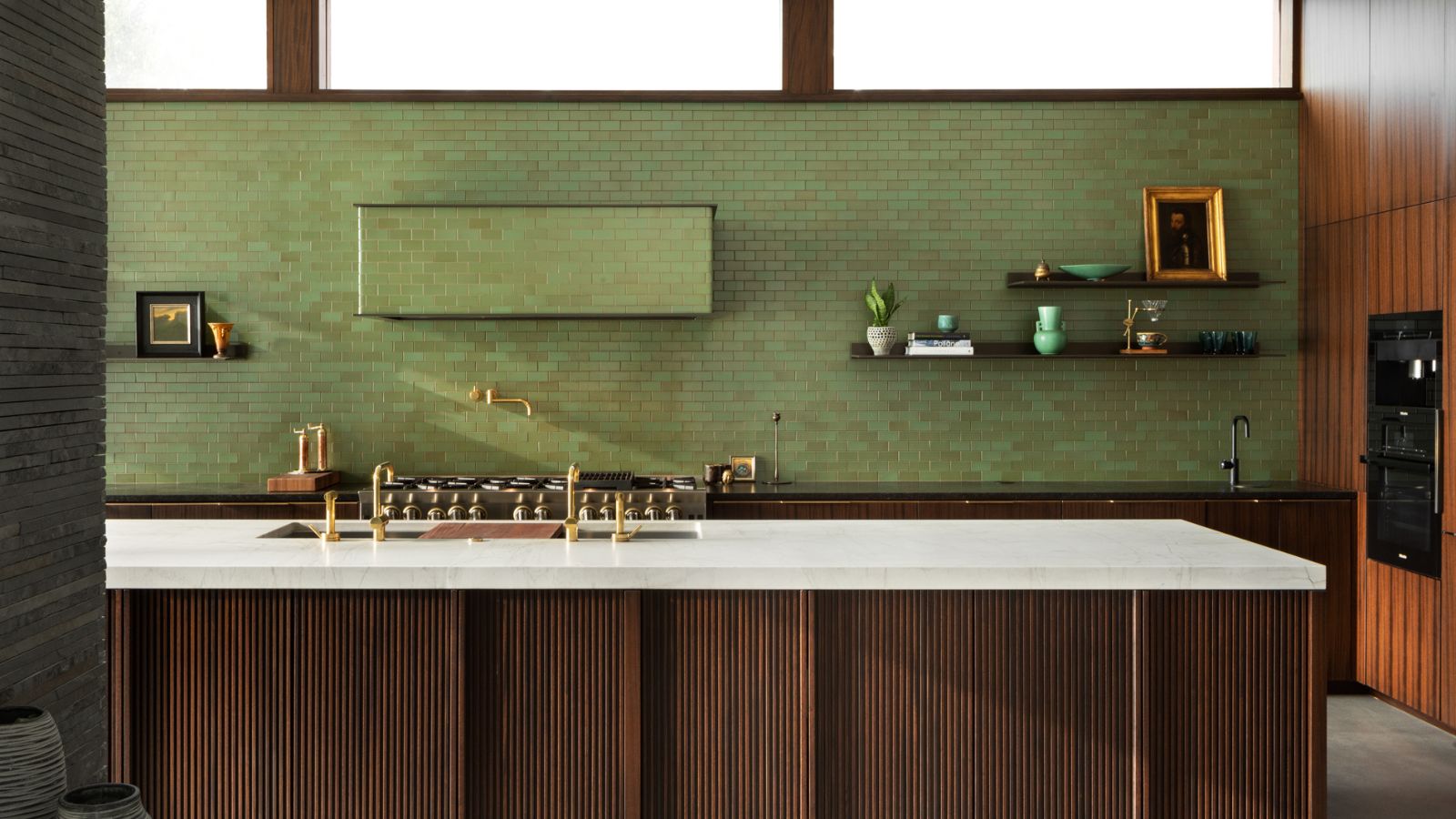 A green tiled kitchen with brown wooden counters and white marbled worktops. 