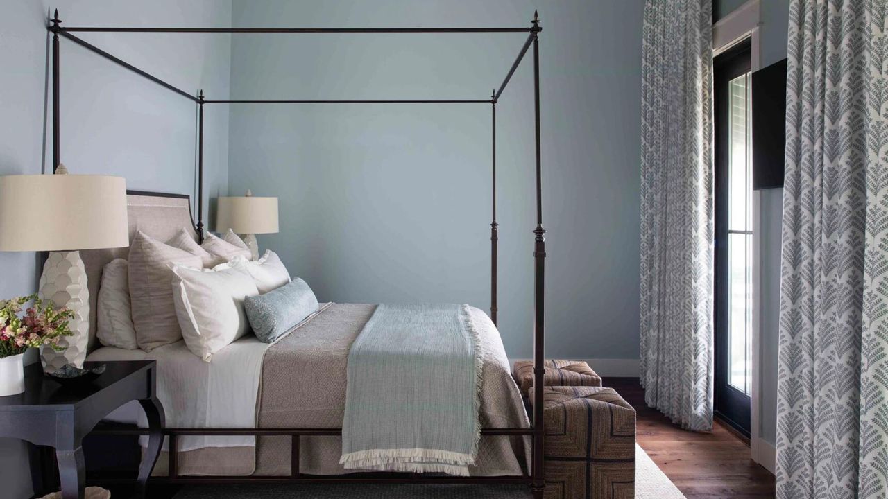 coastal style bedroom with four-poster bed, patterned curtains and light blue walls