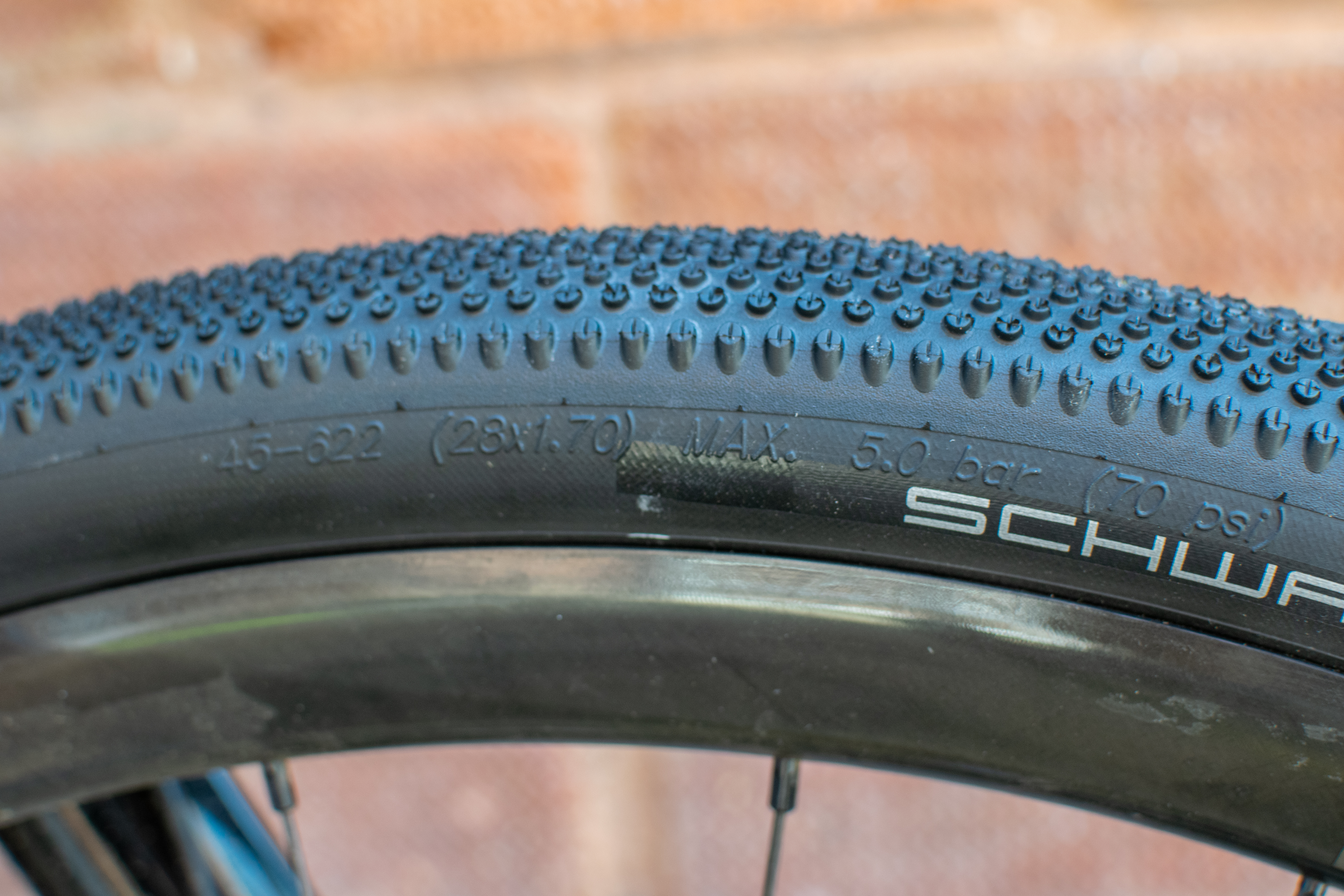 A Schwalbe G One All Round tyre in front of a brick wall