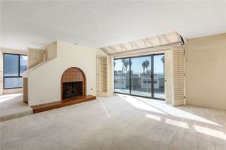 An empty living room with cream carpeted flooring and terracotta tiled fireplace