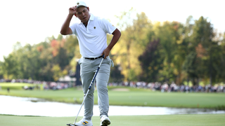 Si Woo Kim removes his cap after striking his putt