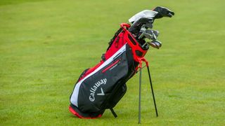 Callaway Fairway 14 Stand Bag in a red and black colorway resting on the golf course