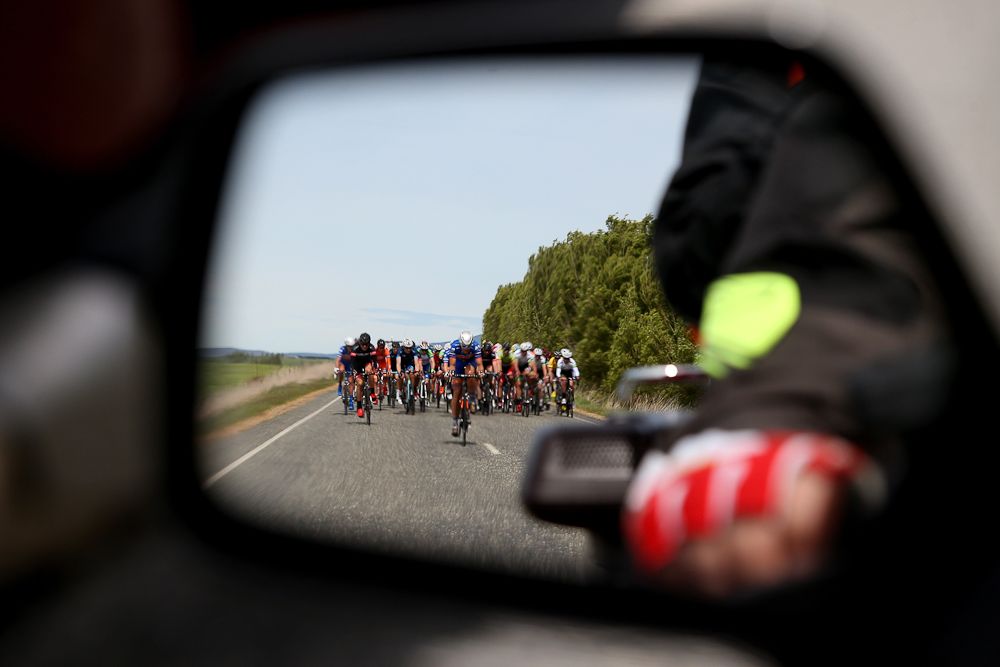 The main peloton as seen in the motorcycle rearview mirror in stage one of the Tour of Southland