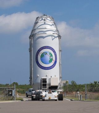 The U.S. National Reconnaissance Office's classified NROL-76 spy satellite, shrouded in its protective payload fairing, is moved to the launch pad to be connected to its SpaceX Falcon 9 rocket ahead of a May 1 launch from Pad 39-A at NASA's Kennedy Space