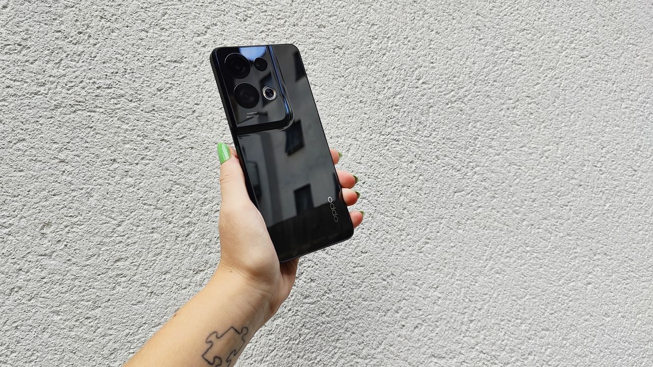 Oppo Reno 8 Pro review: holding phone up against a white wall