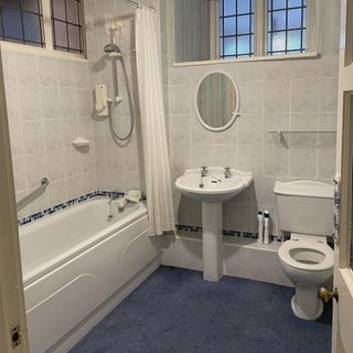 before shot of a dated bathroom with blue carpet
