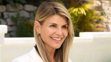 lori loughlin outside against stone wall and white wall