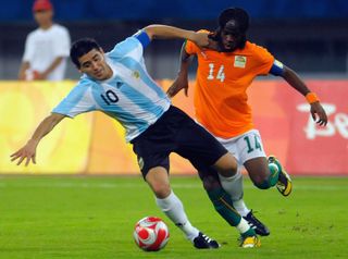 Argentina's Juan Roman Riquelme holds off a challenge from Ivory Coast's Gervinho at the 2008 Olympic Games in Beijing.
