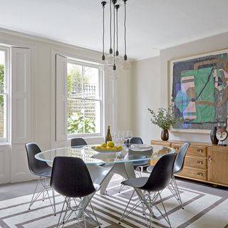 dining area with glass dining table and black chairs