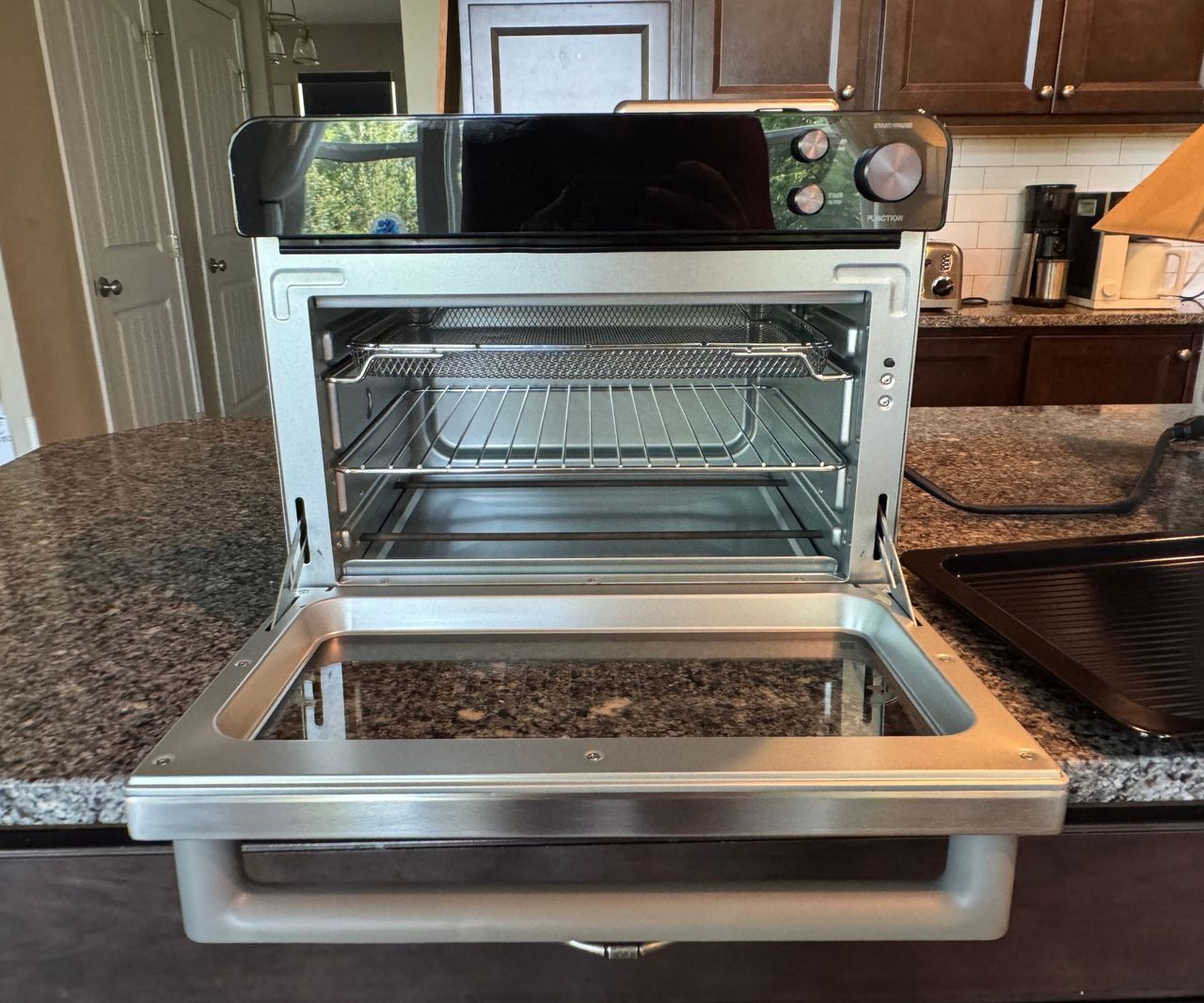 The Typhur Sync Air Fryer Oven on a granite work top open