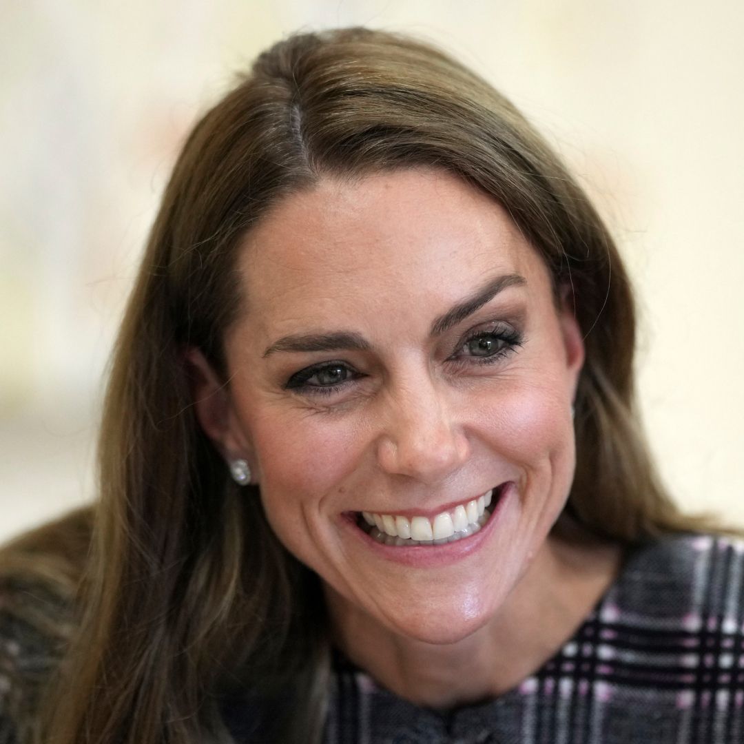 Kate Middleton smiling in a plaid dress