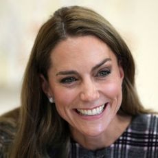 Kate Middleton smiling in a plaid dress