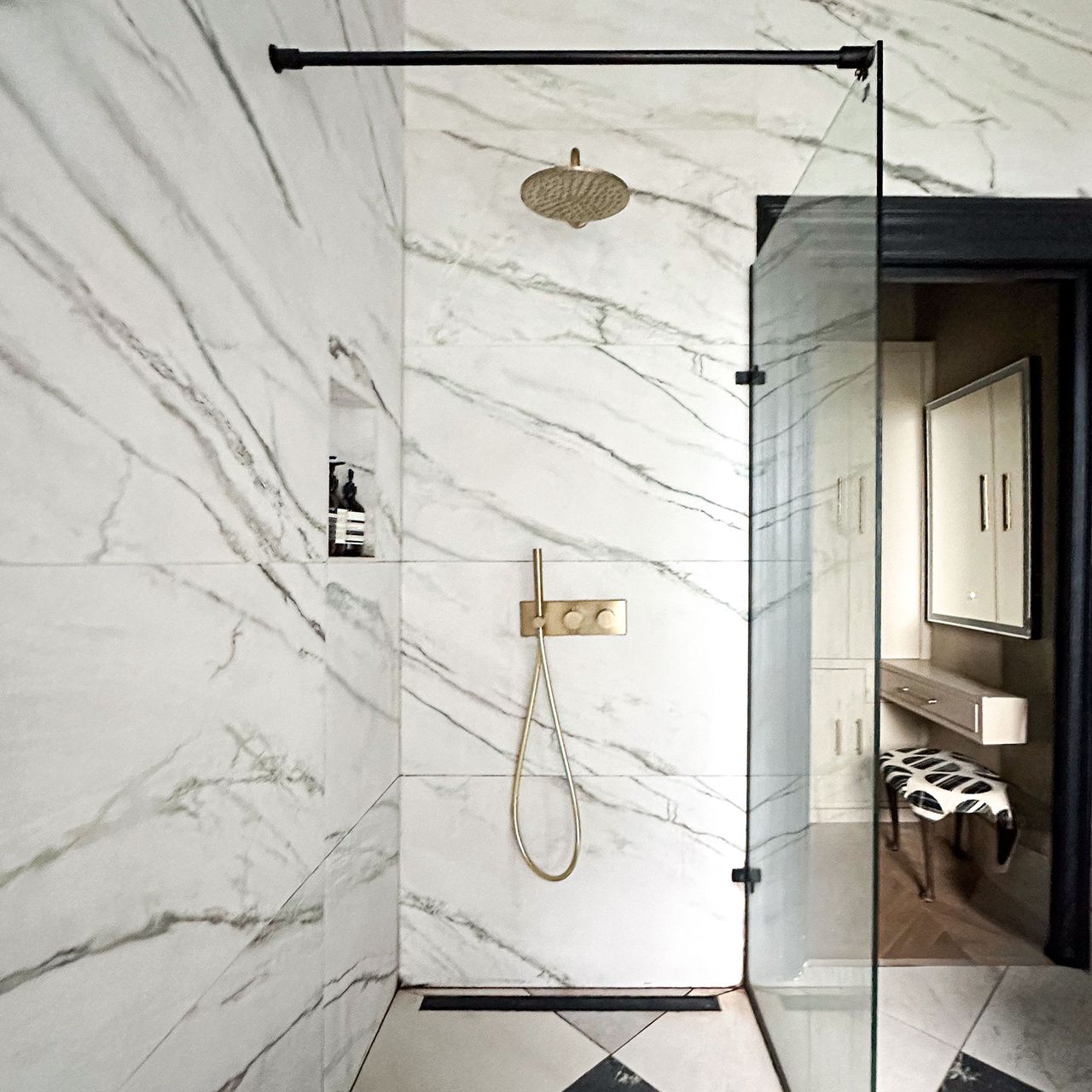 Walk-in shower with glass partition, brass hardware and marble walls and floor